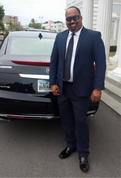 Hombre de traje junto a un vehículo